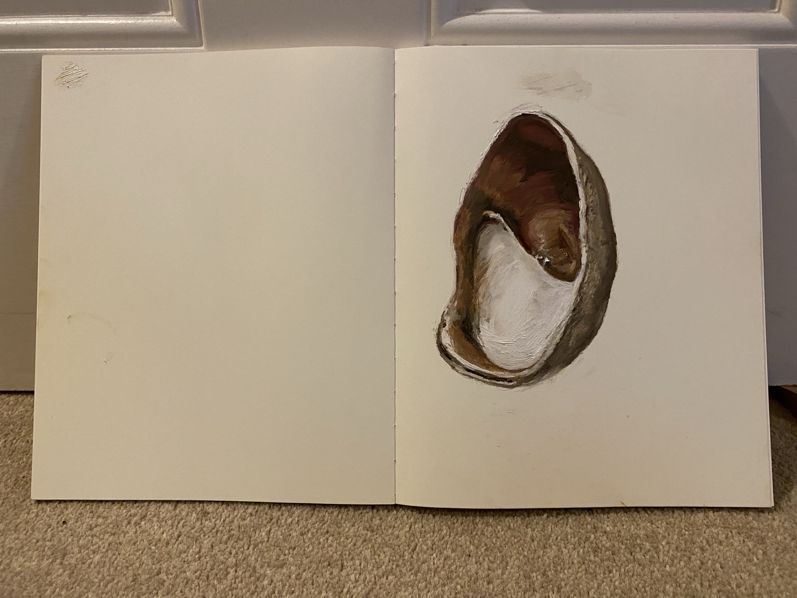 Painting by Jasmin Southgate: a shell across an open sketchbook
